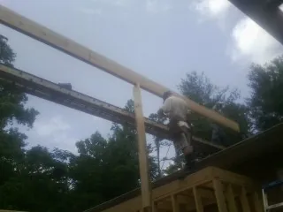Carpenter setting a ridge beam over a new addition frame — Ice Dam Removal by Roofing Brothers in Pevely