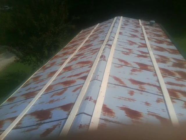 Rusted metal roof panels with new wood purlins before replacement — Storm Damage Roof Repair in Pevely by Roofing Brothers