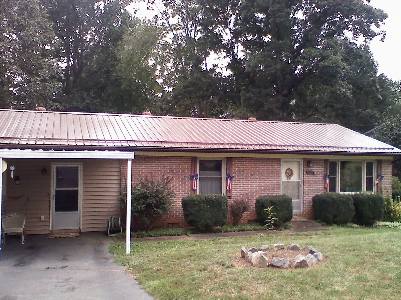 Bronze metal roof and carport on a brick ranch home — Roof Repair work by our crew in Pevely